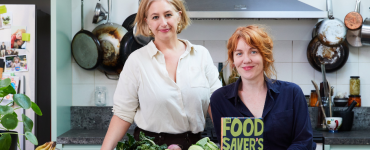 Two women in a kitchen with book 'Food Savers A-Z'.